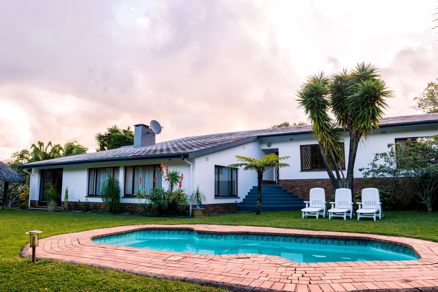 Bushbuck Lodge with its swimming pool and tropical gardens at dusk